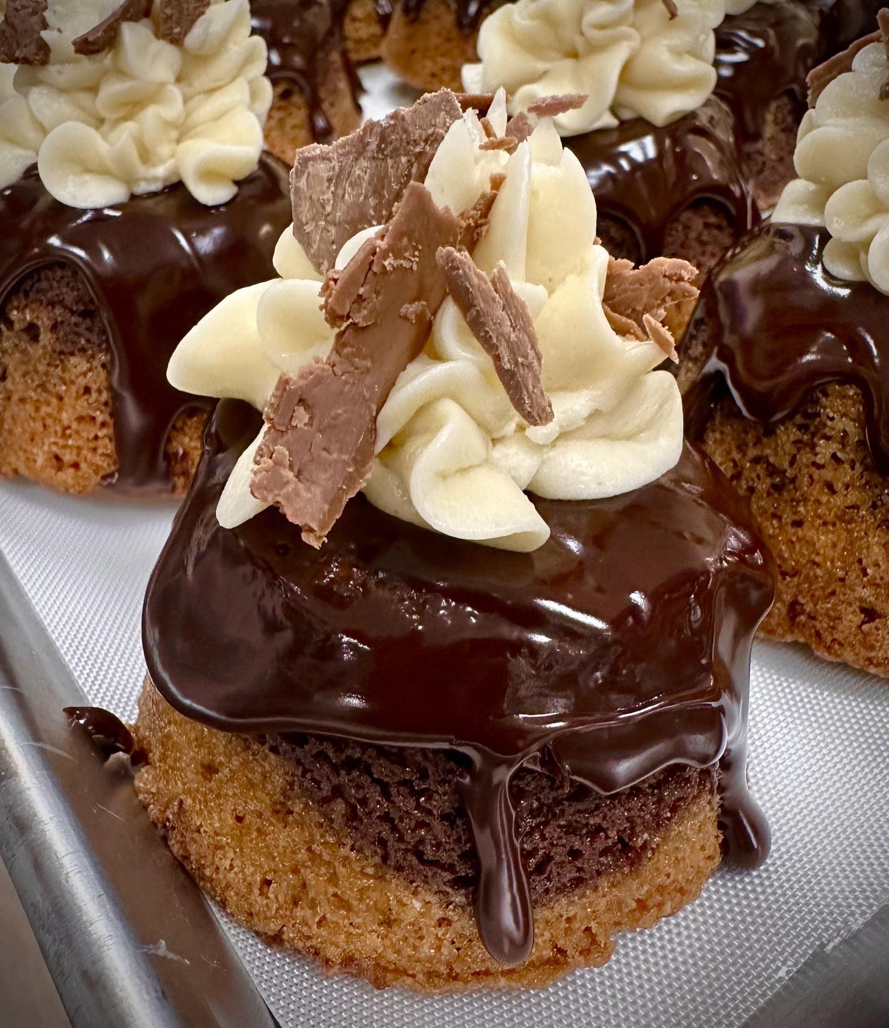 Chocolate-glazed cakes topped with vanilla cream and chocolate shards